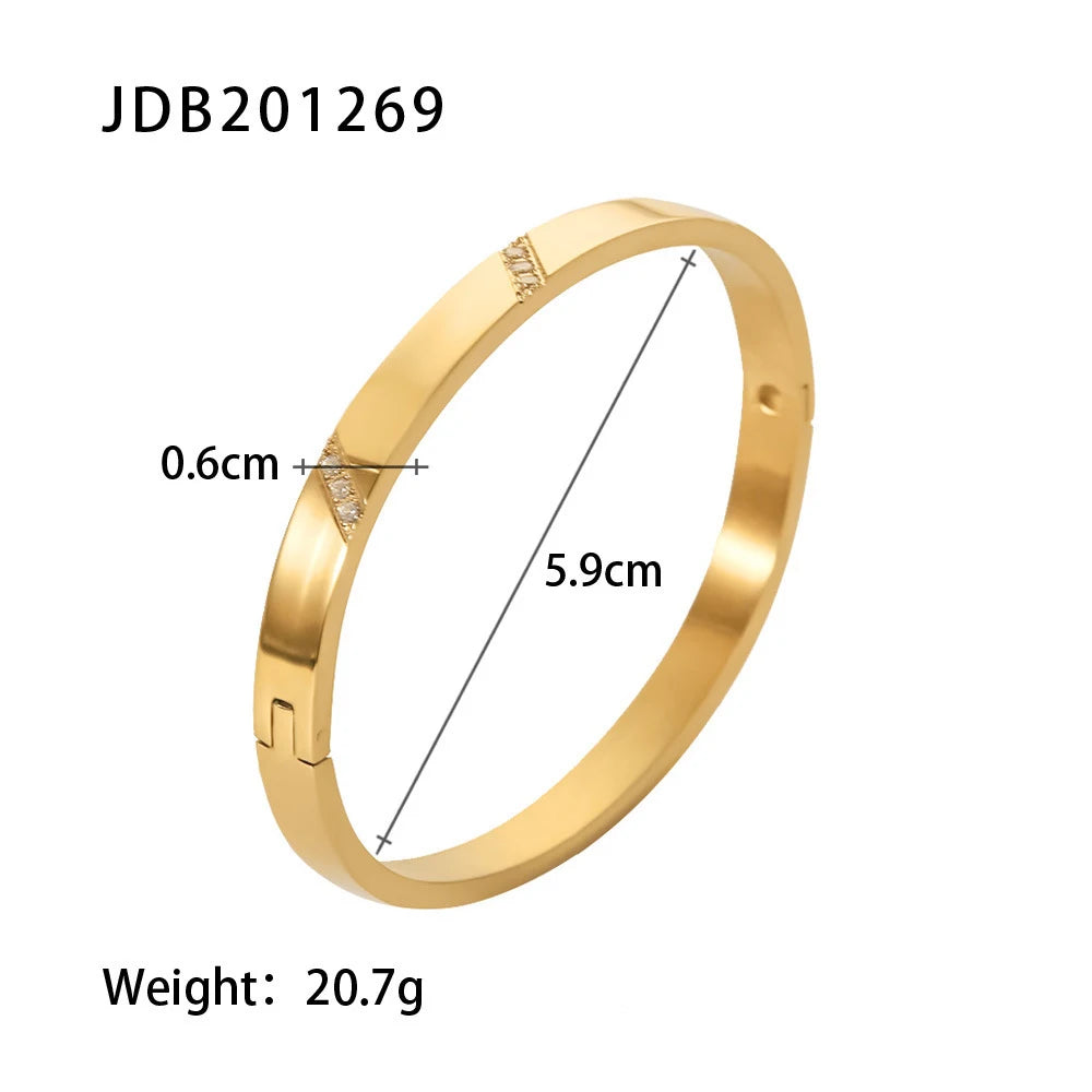 Product specification image showing a polished gold hinged bangle bracelet on a white background with measurements and weight text displaying its diameter and band width, gold hinged bangle bracelet | Oria Jewel