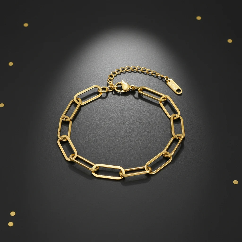 Elegant black background display of a shiny gold paperclip chain bracelet arranged in a circle for a luxe look | Oria Jewel
