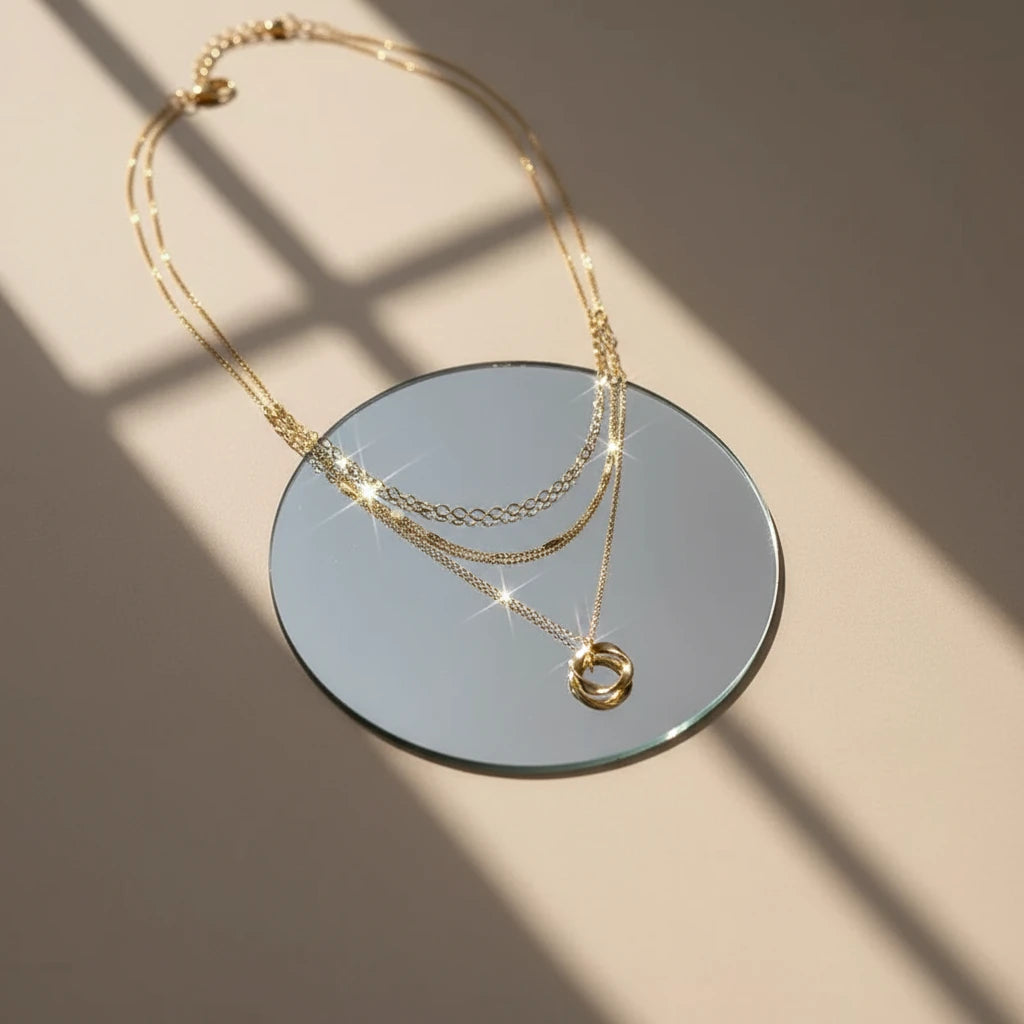 Multi Layered Gold Chain Necklace displayed on round mirror under natural light — sparkling minimalist jewelry look | Oria Jewel