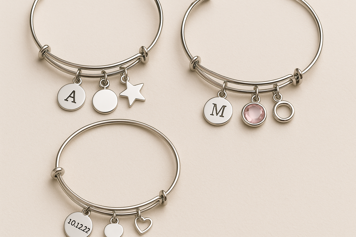 Elegant flat lay of three personalized charm bracelets with minimalist design and silver accents on a soft neutral background | Oria Jewel