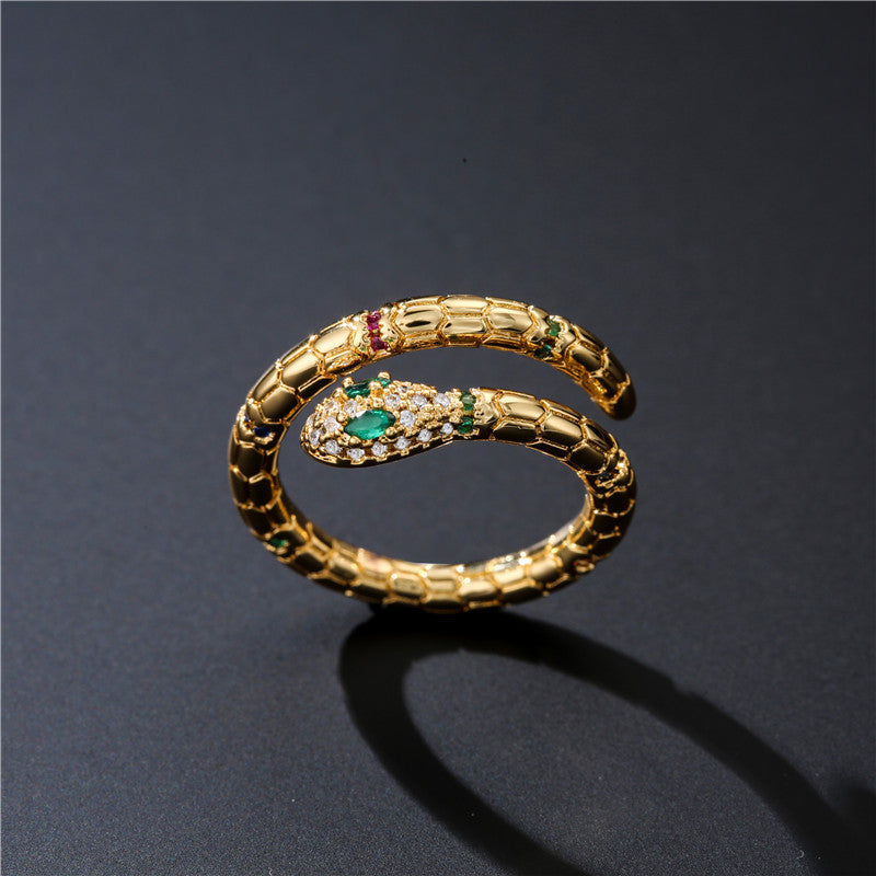Adjustable gold snake ring with emerald and ruby accents, perfect for bold fashion statements.