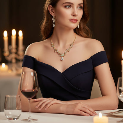 Elegant woman wearing off-the-shoulder dress with a Golden Crystal Set necklace and earrings, dining with candles | Oria Jewel