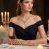 Elegant woman wearing off-the-shoulder dress with a Golden Crystal Set necklace and earrings, dining with candles | Oria Jewel