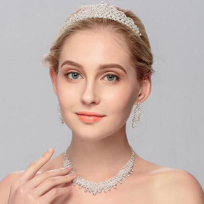 Elegant wedding jewelry set featuring a crown and matching necklace and earrings, showcasing bridal elegance and sophistication.