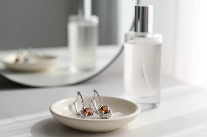 Amber Orange Drop Huggie Earrings in dish with perfume vanity background | OriaJewel