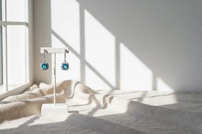 Aqua Blue Drop Huggie Earrings on white stand with soft window-light shadows | OriaJewel
