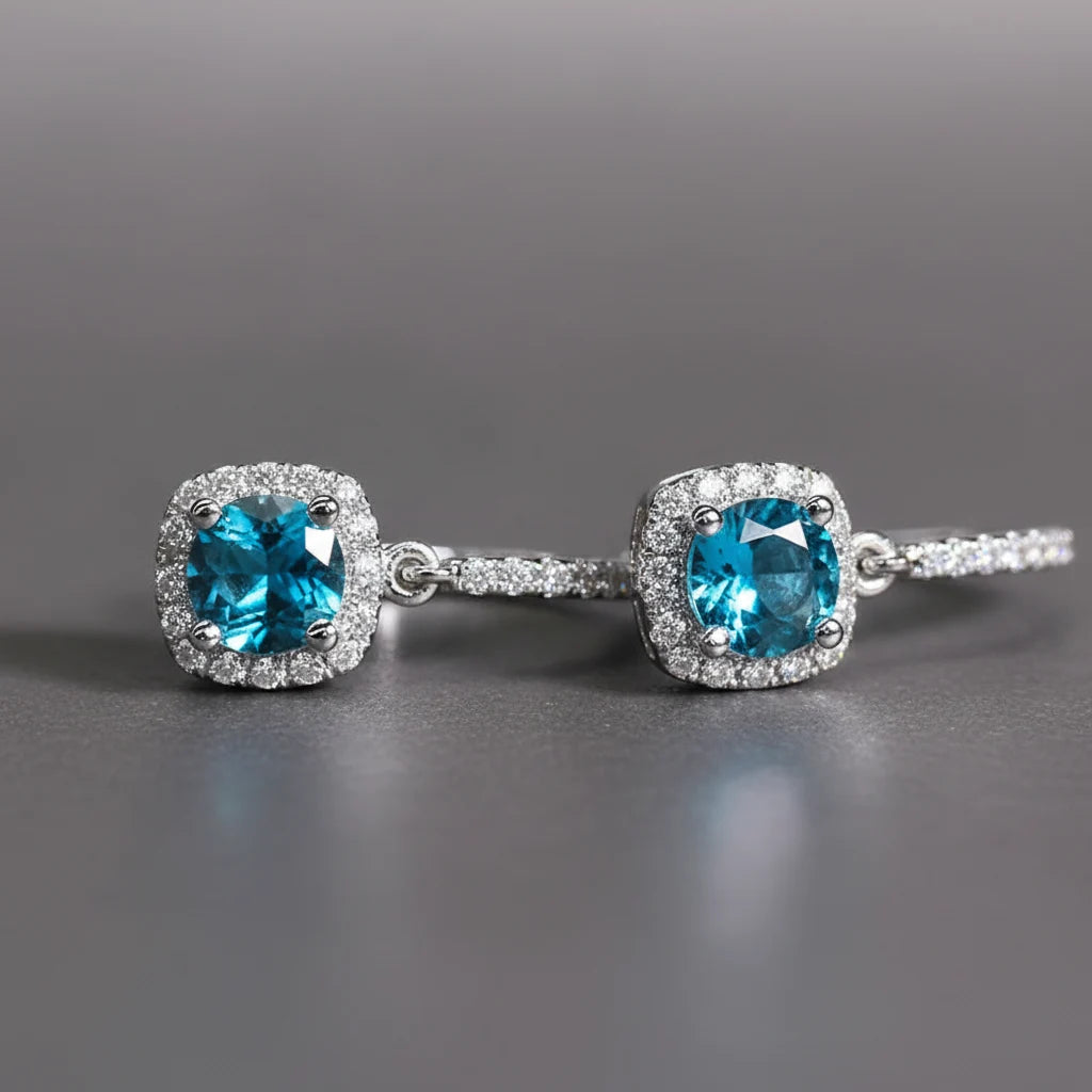 Aqua Blue Drop Huggie Earrings macro close-up on gray background showing blue stones | OriaJewel
