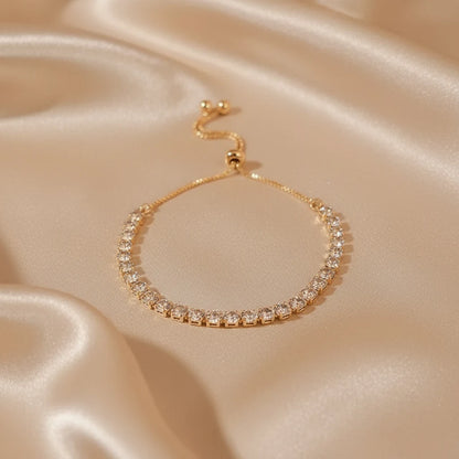 Gold Aurelia Cluster Tennis Bracelet resting on champagne satin fabric, shimmering crystals reflecting warm light for a luxurious, romantic jewelry flatlay | Oria Jewel