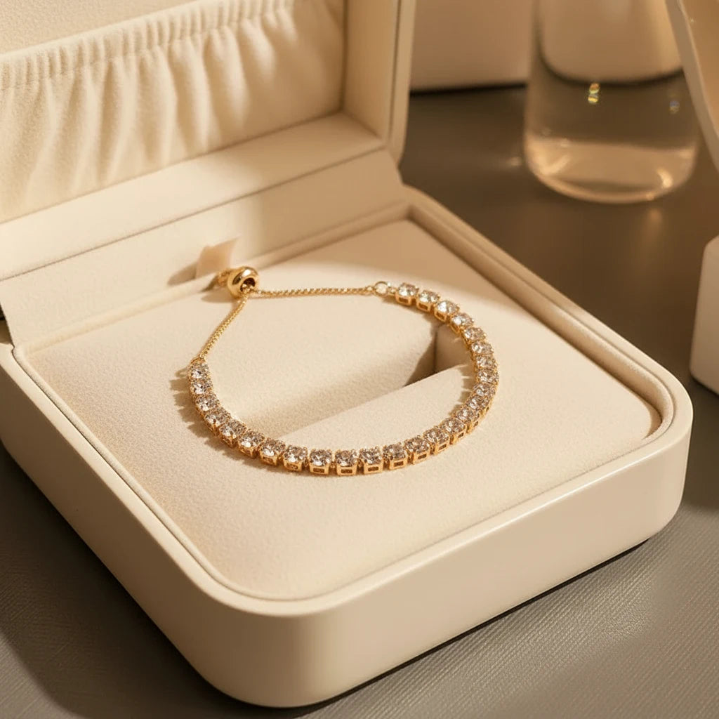 Gold Aurelia Cluster Tennis Bracelet presented inside an open cream jewelry box, cushion lining and soft lighting emphasizing the brilliance of each crystal | Oria Jewel