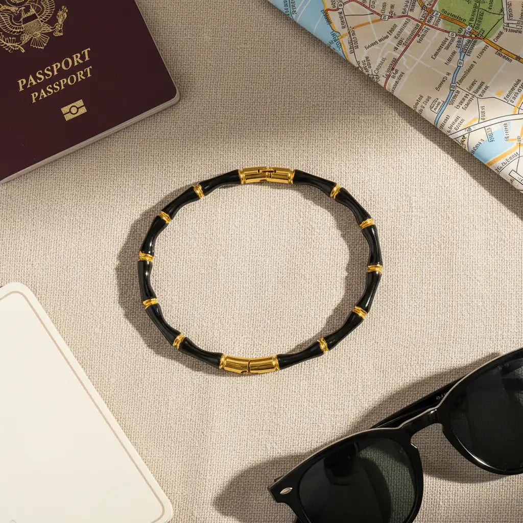 Flat lay of Black Bamboo bangle Bracelet arranged with passport, city map, and black sunglasses, styled as an elegant travel accessory in natural light | Oria Jewel
