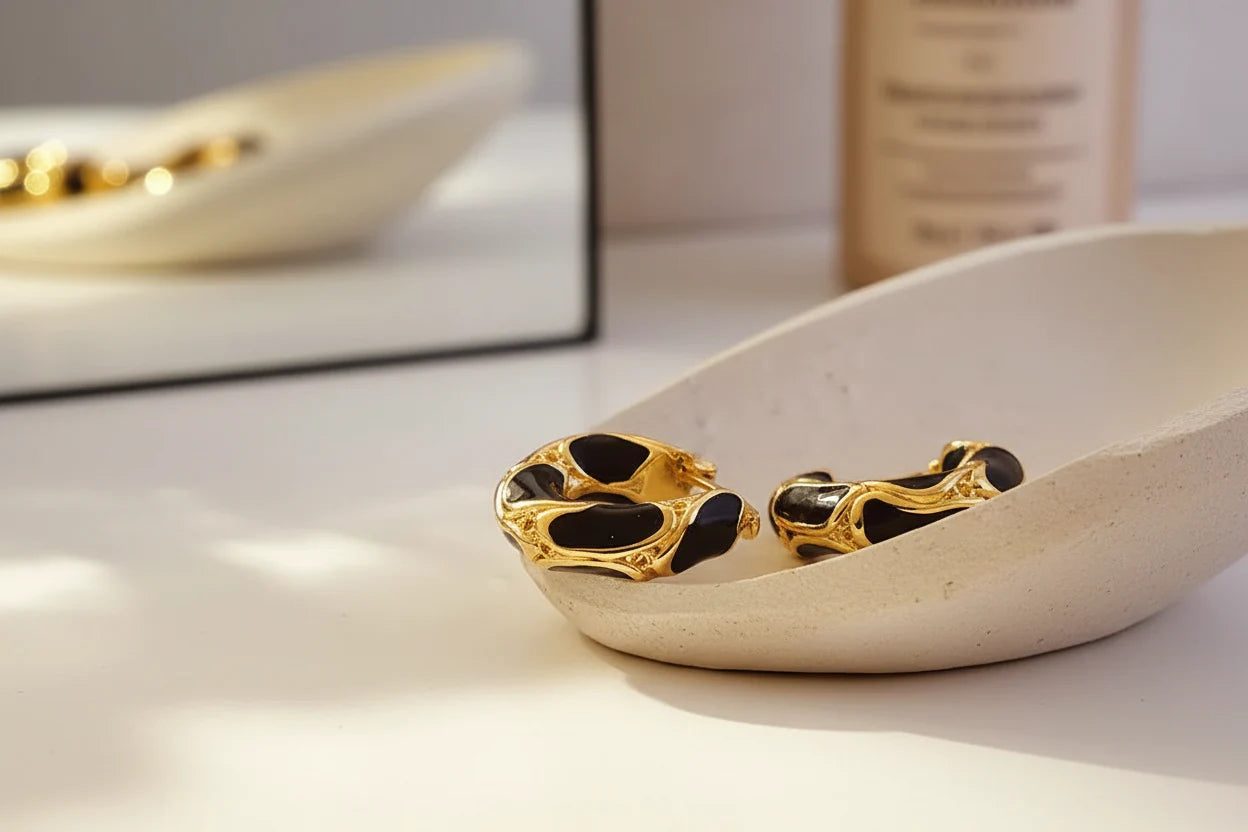 Black Huggie Hoop Earrings on ceramic dish with mirror and perfume backdrop | OriaJewel