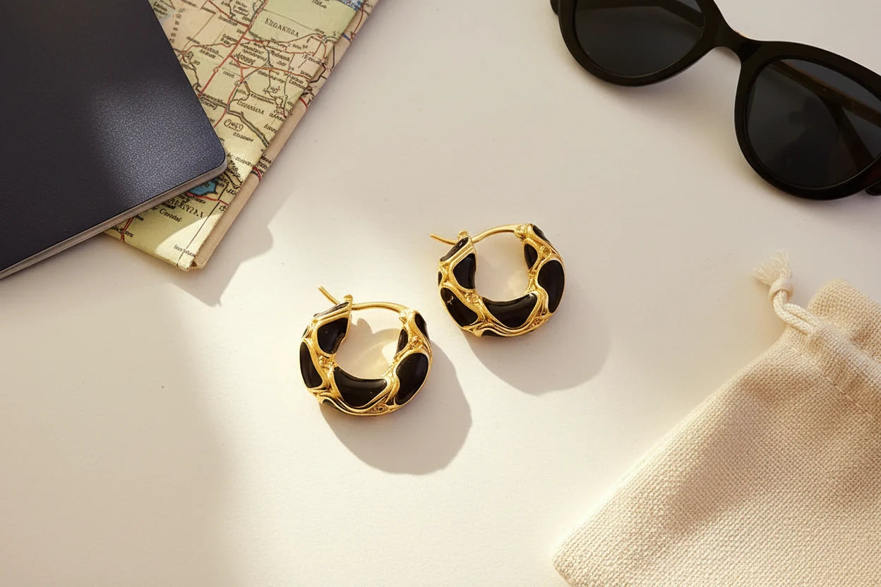 Black Huggie Hoop Earrings flat lay with notebook, map, and sunglasses | OriaJewel