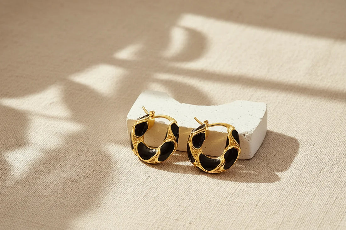 Black Huggie Hoop Earrings on textured fabric with soft shadow | OriaJewel