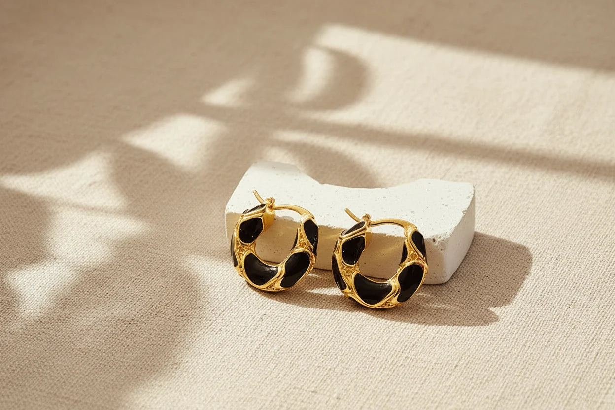 Black Huggie Hoop Earrings on textured fabric with soft shadow | OriaJewel
