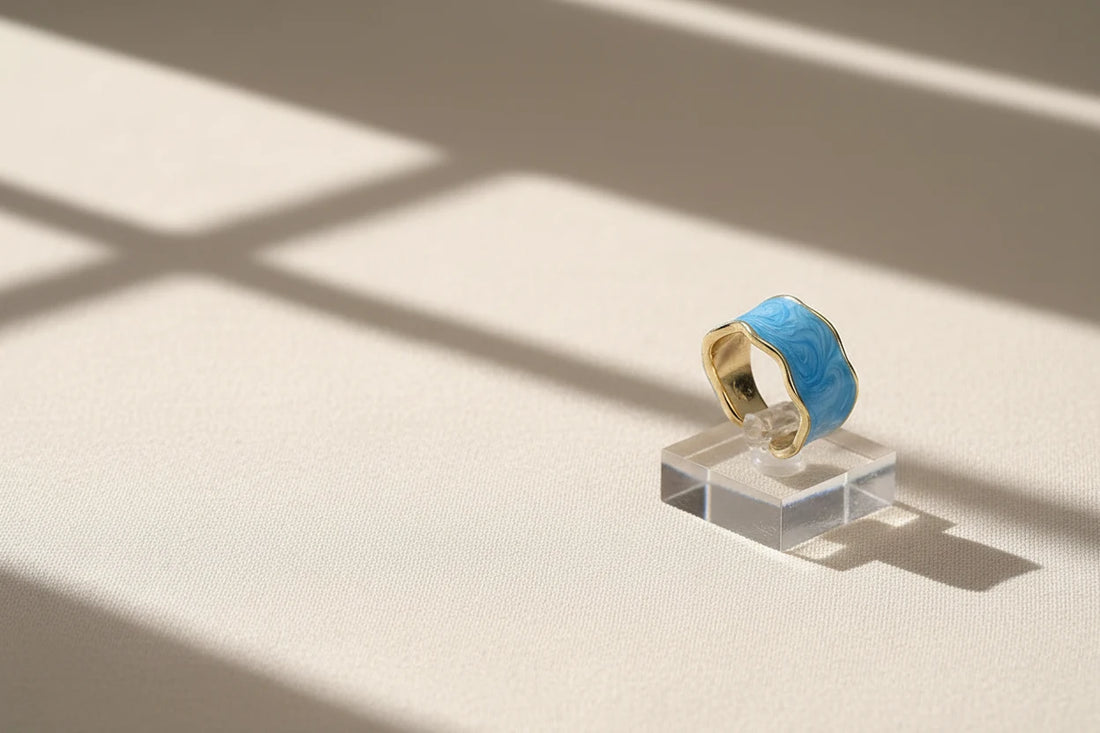 Blue Marble Open Wave Ring displayed on a clear acrylic stand with window-light shadows | OriaJewel