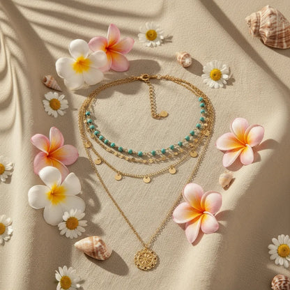 Boho Pendant Necklace Set surrounded by tropical flowers and shells on fabric — summery bohemian vibe | Oria Jewel