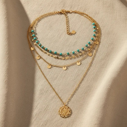 Flat-lay of Boho Pendant Necklace Set on beige fabric — layered gold chains with turquoise accents | Oria Jewel