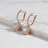 Bronze Crystal Drop Huggie Earrings close-up angled view on white marble ledge | OriaJewel