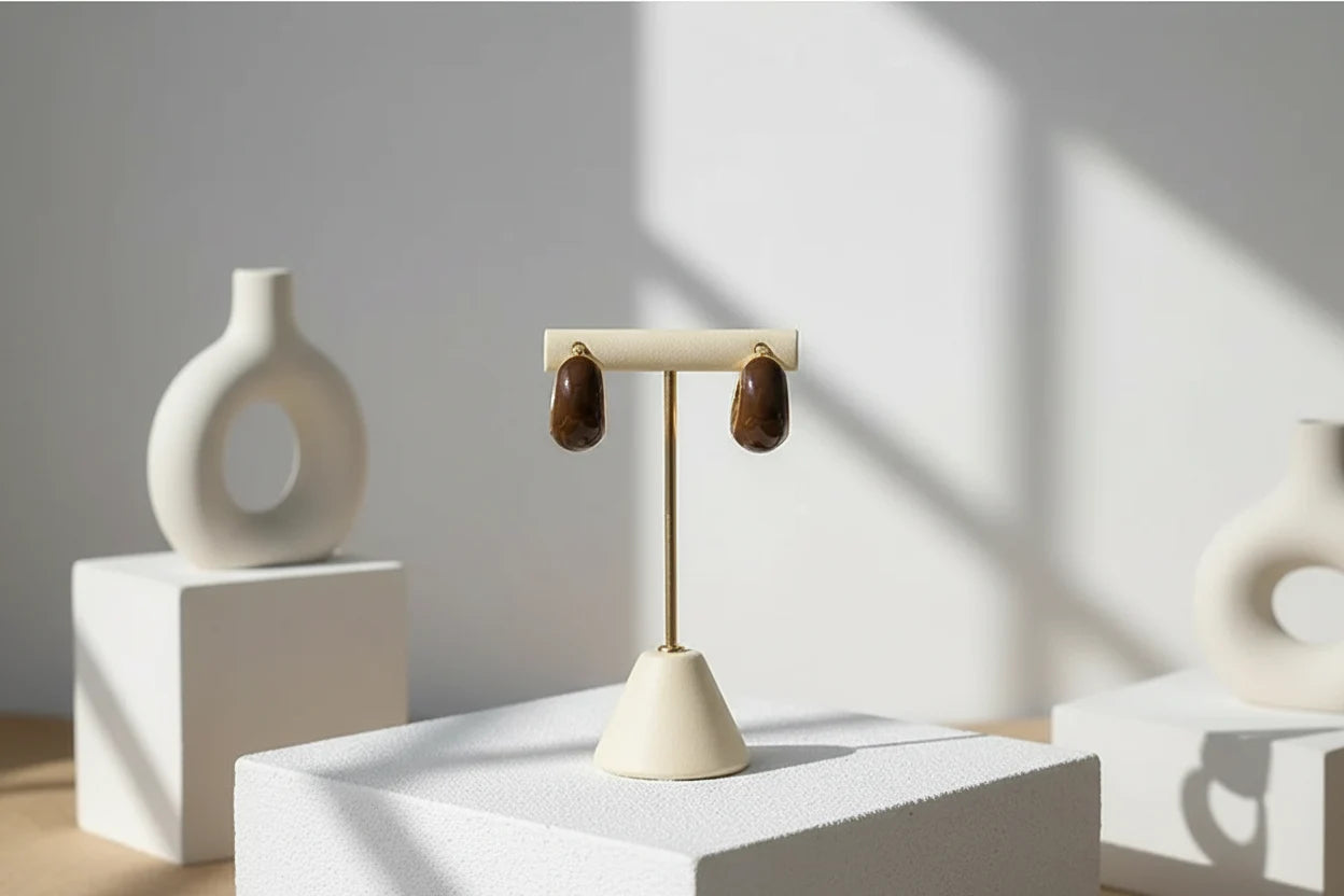 Brown Resin Huggie Hoop Earrings on display stand with modern decor in sunlight | OriaJewel