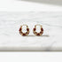 Burgundy Huggie Hoop Earrings close-up on marble background | OriaJewel