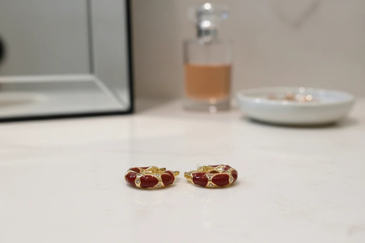 Burgundy Huggie Hoop Earrings on vanity surface with soft blur background | OriaJewel