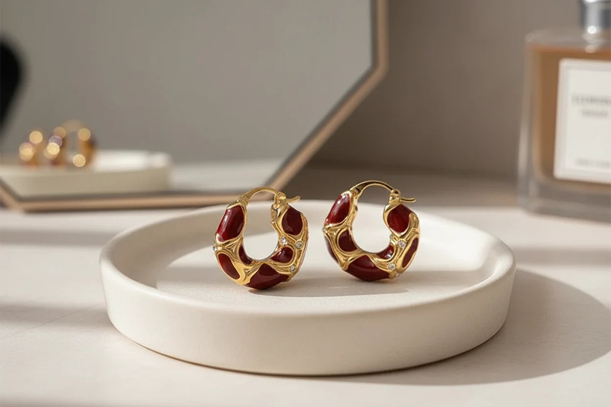 Burgundy Red Huggie Hoop Earrings on round dish with mirror and perfume backdrop | OriaJewel