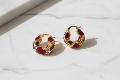 Burgundy Red Huggie Hoop Earrings close-up on white marble surface | OriaJewel