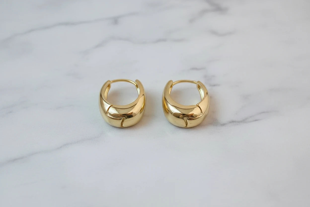 Chunky Gold Huggie Hoop Earrings close-up pair on marble background | OriaJewel