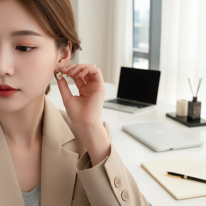 Colorful Heart Huggie Hoop Earrings worn on model at office desk | OriaJewel