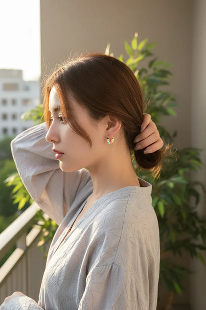 Colorful Heart Huggie Hoop Earrings worn on model at sunset balcony | OriaJewel
