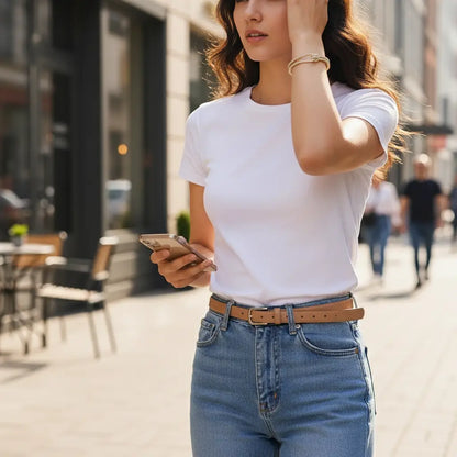 Casual street style outfit with white T-shirt and jeans, highlighted by a gold Crystal Knot Cuff Bracelet on the wrist | Oria jewel