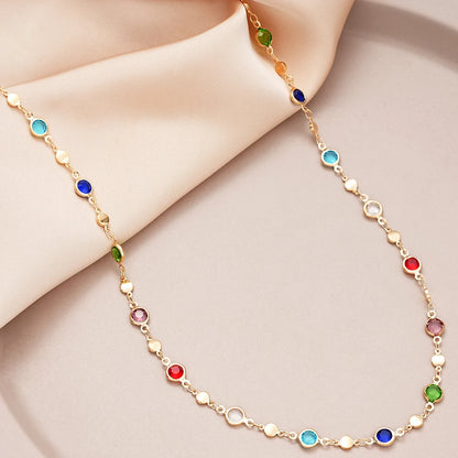 Crystal Y Necklace featuring colorful gemstones and a delicate gold chain on a soft fabric backdrop | Oria Jewel