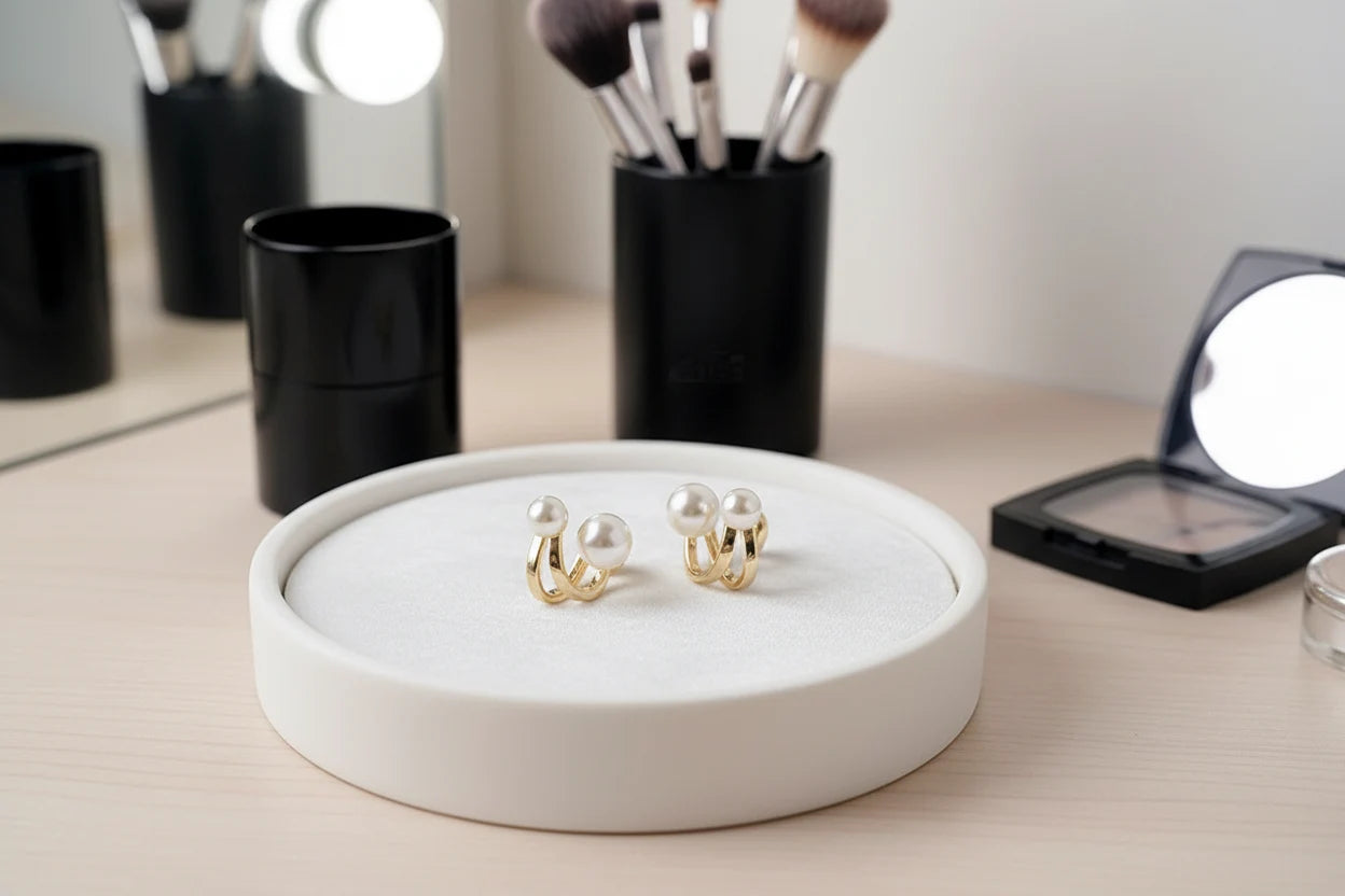 Double Pearl Huggie Hoop Earrings on jewelry tray with makeup tools | OriaJewel