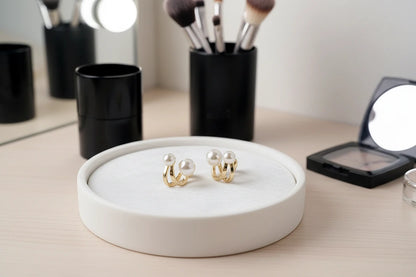Double Pearl Huggie Hoop Earrings on jewelry tray with makeup tools | OriaJewel