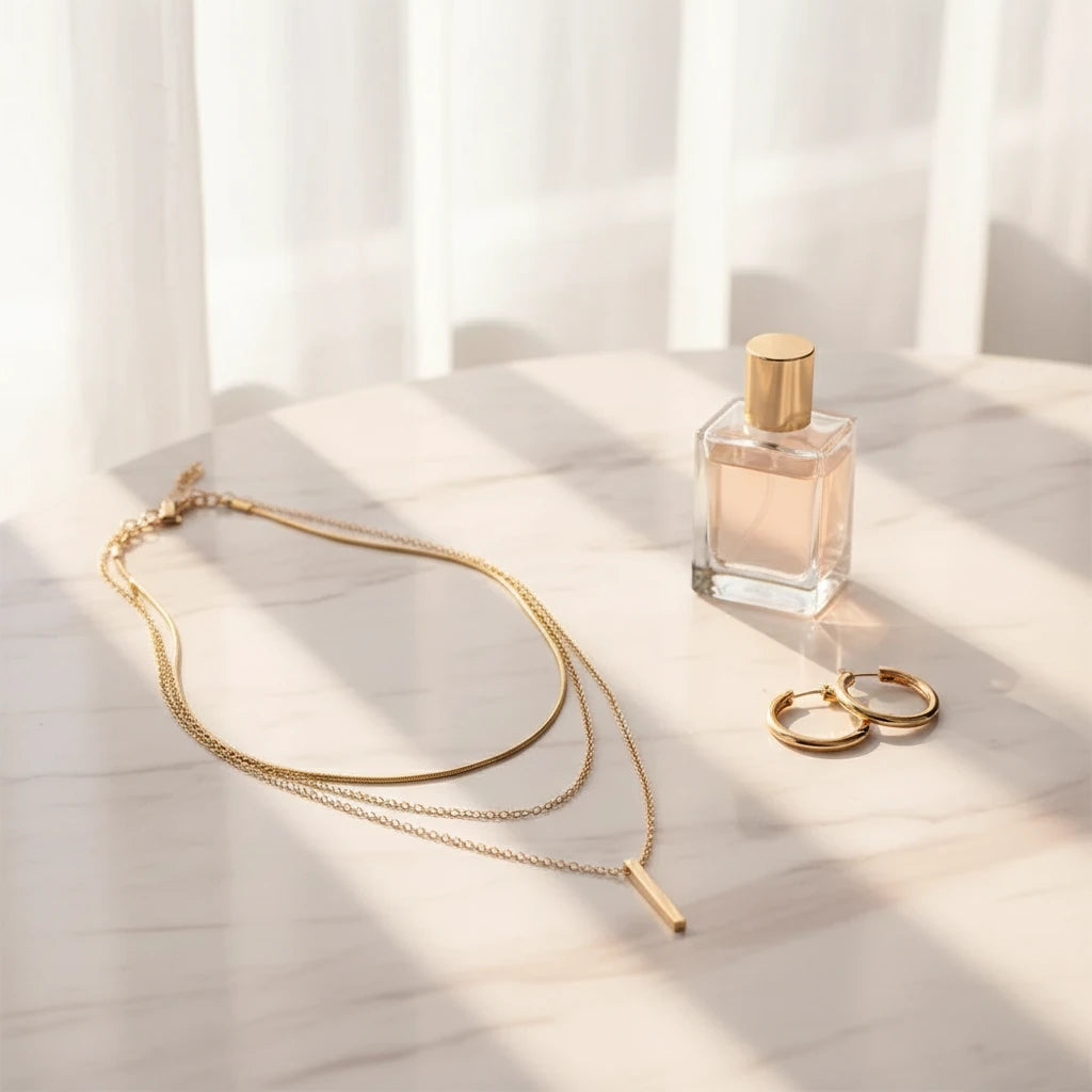 Drop Bar Pendant Necklace styled with gold hoop earrings and perfume bottle on marble table in sunlight | Oria Jewel