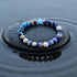 Earth Energy Crystal Bracelet resting on wet black stone surrounded by rippling water | Oria Jewel