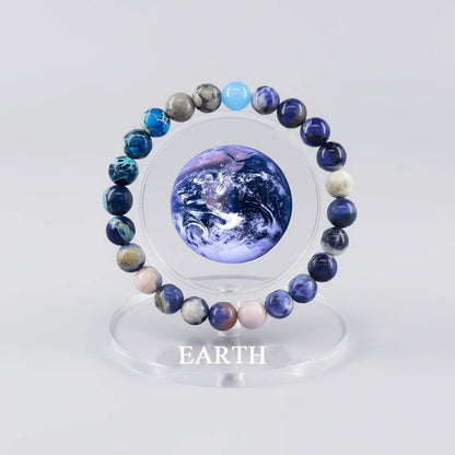 Earth Energy Crystal Bracelet displayed around planet Earth graphic on clear acrylic stand | Oria Jewel
