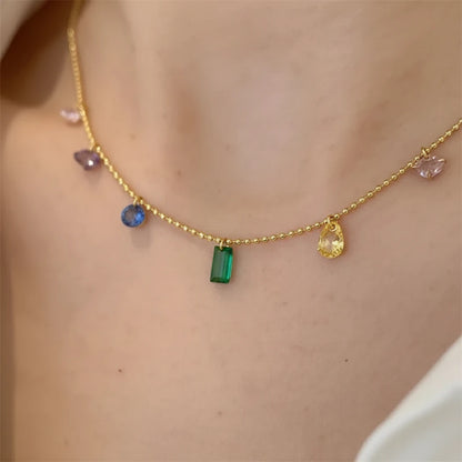 Macro shot of Elegant Zircon Necklace highlighting emerald green and pastel gemstone charms on gold chain | Oria Jewel