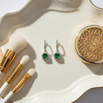 Emerald Green Drop Huggie Earrings flat lay on ivory tray with makeup brushes | OriaJewel