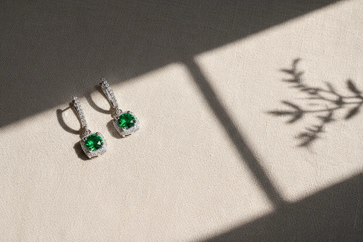 Emerald Green Drop Huggie Earrings on textured fabric with natural shadow | OriaJewel