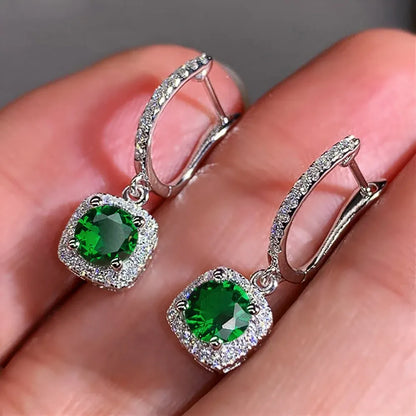 Emerald Green Drop Huggie Earrings in-hand close-up showing clasp and sparkle | OriaJewel