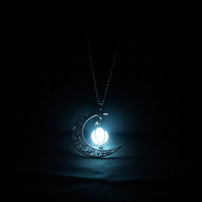 Close-up of single Glowing Moon Locket shining with intense white-blue light in total darkness, highlighting crescent silhouette | Oria Jewel