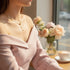 Gold Butterfly Chain Necklace worn with pink off-shoulder blouse at cozy café setting | Oria Jewel