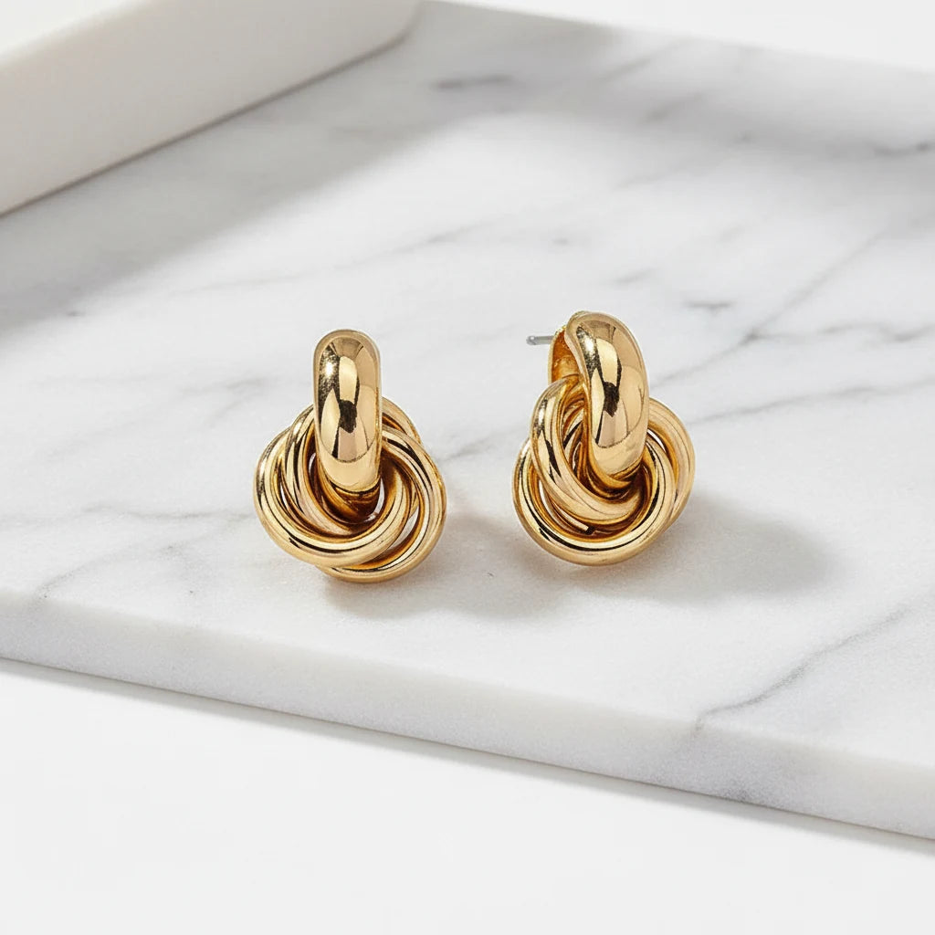 Gold Chunky Knot Stud Earrings pair on marble surface close-up | OriaJewel