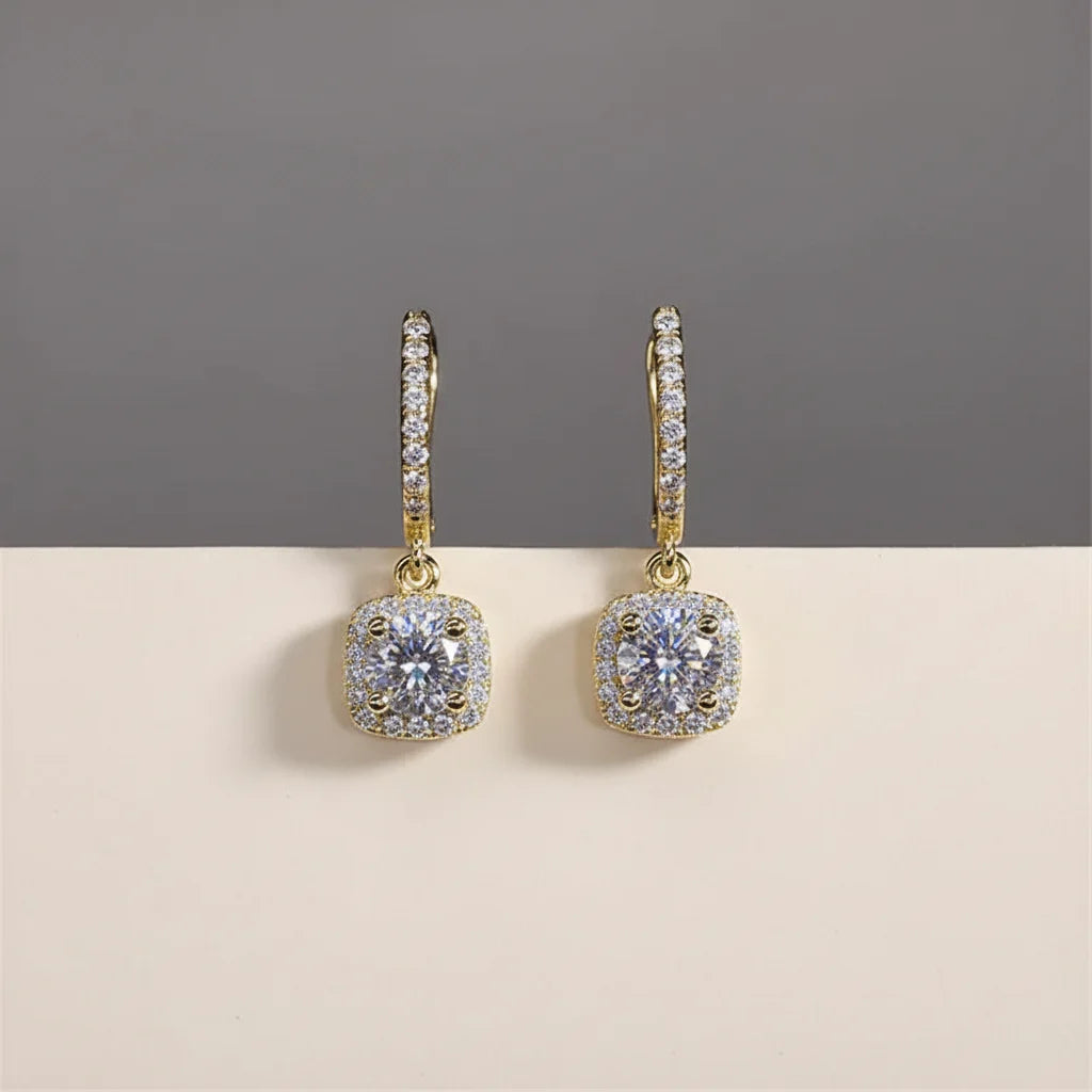Gold Crystal Drop Huggie Earrings close-up front view on gray and beige backdrop | OriaJewel