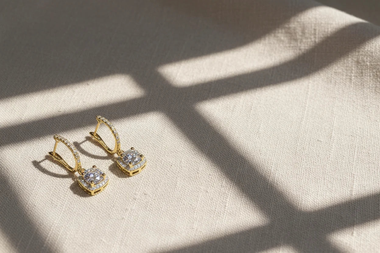 Gold Crystal Drop Huggie Earrings on textured fabric with soft window-light shadows | OriaJewel