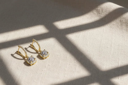 Gold Crystal Drop Huggie Earrings on textured fabric with soft window-light shadows | OriaJewel
