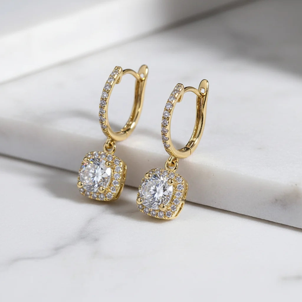 Gold Crystal Drop Huggie Earrings angled macro on white marble surface | OriaJewel