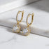 Gold Crystal Drop Huggie Earrings angled macro on white marble surface | OriaJewel