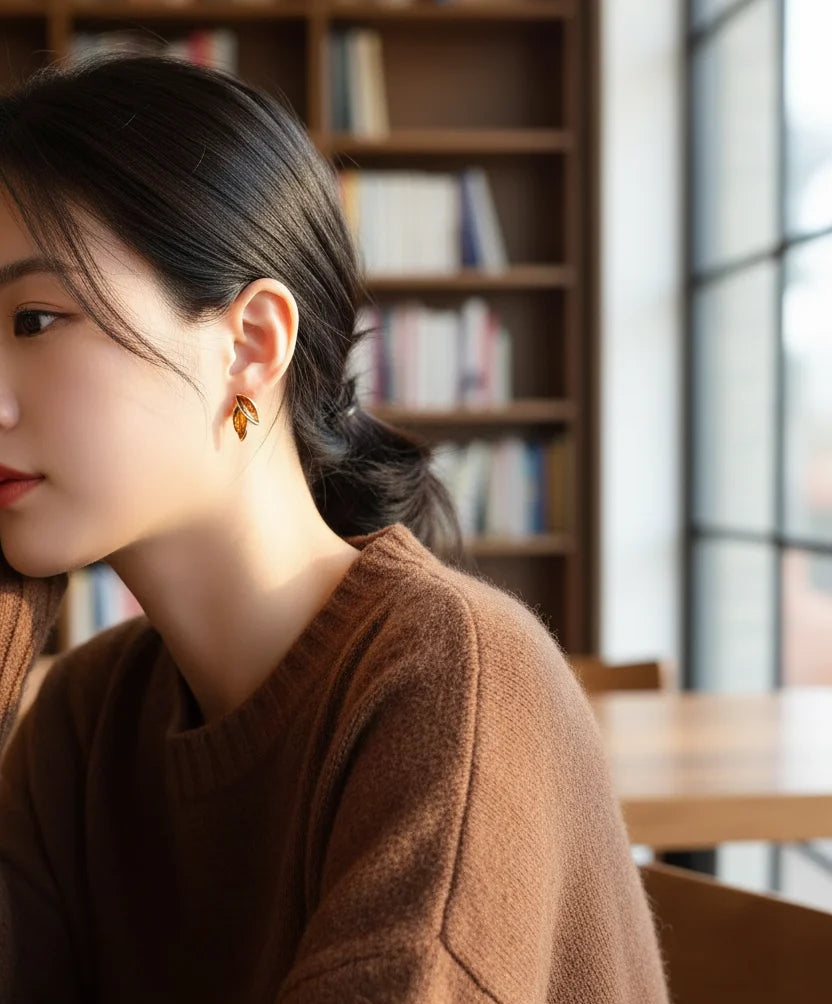 Gold Double Leaf Stud Earrings on model in cozy library cafe close-up | OriaJewel